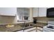 Bright kitchen featuring granite countertops, a stainless sink, and white appliances at 2213 Fluorshire Dr, Brandon, FL 33511