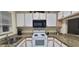 Well-lit kitchen with granite countertops, white cabinetry and black microwave offers style and function at 2213 Fluorshire Dr, Brandon, FL 33511