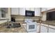 Efficient kitchen features granite countertops, black microwave and white appliances at 2213 Fluorshire Dr, Brandon, FL 33511