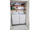 The laundry closet features a stacked washer and dryer, as well as extra shelving for storage at 2213 Fluorshire Dr, Brandon, FL 33511