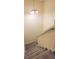 Carpeted staircase with a white railing, illuminated by a chandelier, providing a cozy and stylish transition between floors at 2213 Fluorshire Dr, Brandon, FL 33511