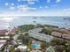 An aerial view showcases the community, pool, and the water nearby at 2700 Bayshore Blvd # 522, Dunedin, FL 34698