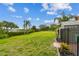Expansive backyard with lush green lawn leading to a scenic water view and palm trees at 2700 Bayshore Blvd # 522, Dunedin, FL 34698