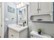 Bright bathroom with white vanity, toilet, mirror, and wall decorations at 2700 Bayshore Blvd # 522, Dunedin, FL 34698