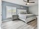 Comfortable primary bedroom with blue walls, shuttered window, ceiling fan and wood-look floors at 2700 Bayshore Blvd # 522, Dunedin, FL 34698