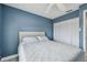 Bedroom showcases calming blue walls, a ceiling fan, and a spacious closet for ample storage at 2700 Bayshore Blvd # 522, Dunedin, FL 34698