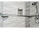 Modern shower showcasing textured white tiles, built-in shelving, and a sleek showerhead at 2700 Bayshore Blvd # 522, Dunedin, FL 34698