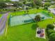 Aerial view of community tennis court with green turf, new surfacing, fenced in area, and bike rack at 2700 Bayshore Blvd # 522, Dunedin, FL 34698