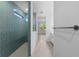 Spa-like bathroom featuring blue tiled shower and view into vanity area and window for natural light at 29156 Coral Harbour Dr, Englewood, FL 34223