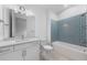 Modern bathroom featuring a blue tiled shower, white vanity, and neutral floors at 29156 Coral Harbour Dr, Englewood, FL 34223
