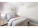 A cozy bedroom features a chandelier, decorative artwork, and a plush bed with pastel accents at 29156 Coral Harbour Dr, Englewood, FL 34223