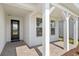 Inviting front porch with brick pavers, white pillars, and a stylish glass-paneled front door at 29156 Coral Harbour Dr, Englewood, FL 34223