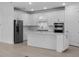 Bright kitchen featuring white cabinets, stainless steel appliances, and a large island with breakfast bar seating at 29156 Coral Harbour Dr, Englewood, FL 34223