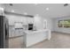 Bright kitchen with white cabinets, a central island, and modern stainless steel appliances at 29156 Coral Harbour Dr, Englewood, FL 34223