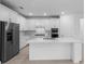 Elegant kitchen with white cabinetry, stainless steel refrigerator, and spacious island at 29156 Coral Harbour Dr, Englewood, FL 34223