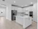Modern kitchen featuring white cabinets, stainless steel appliances, and a center island at 29156 Coral Harbour Dr, Englewood, FL 34223