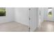 Open room displaying view into front entry door, bright white walls, baseboard trim, tile floor, and front facing window at 29156 Coral Harbour Dr, Englewood, FL 34223