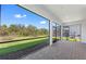 Screened-in patio with brick flooring offers peaceful views of the lawn, trees, and a private pool at 29156 Coral Harbour Dr, Englewood, FL 34223
