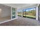 A covered patio features brick flooring and an expansive view of the green lawn and woods beyond at 29156 Coral Harbour Dr, Englewood, FL 34223