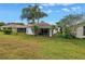 Charming backyard featuring lush green grass and mature palm trees at 3009 Banyan Hill Ln, Land O Lakes, FL 34639