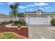 Well-maintained home with landscaped yard, mature palms, and a two-car garage at 3009 Banyan Hill Ln, Land O Lakes, FL 34639
