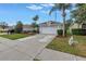 Inviting single-story home with a two-car garage, manicured lawn, and lush tropical landscaping at 3009 Banyan Hill Ln, Land O Lakes, FL 34639