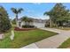 Attractive single-story home with a two-car garage, green lawn, and mature palm trees at 3009 Banyan Hill Ln, Land O Lakes, FL 34639