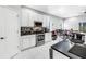 Kitchen featuring stainless steel appliances, white cabinets, and black countertops at 3009 Banyan Hill Ln, Land O Lakes, FL 34639