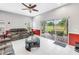 Bright living room features a gray couch and access to outdoor screened patio at 3009 Banyan Hill Ln, Land O Lakes, FL 34639