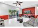 Bright living room features a red accent wall and access to outdoor screened patio at 3009 Banyan Hill Ln, Land O Lakes, FL 34639