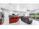 Open floor plan with white tile flooring, gray couches, and patio access at 3009 Banyan Hill Ln, Land O Lakes, FL 34639