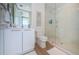 Modern bathroom with white vanity, decorative wallpaper, and glass shower door at 301 1St S St # 3004, St Petersburg, FL 33701