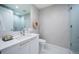 Stylish bathroom featuring wallpaper, white cabinets, and frameless shower enclosure at 301 1St S St # 3004, St Petersburg, FL 33701