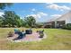 Inviting backyard featuring a custom brick fire pit with Adirondack chairs at 30723 Reed Rd, Dade City, FL 33523