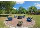 Inviting backyard featuring a custom brick fire pit with Adirondack chairs at 30723 Reed Rd, Dade City, FL 33523