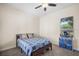 A bedroom with a plaid comforter and carpet, alongside a view outside of the window at 30723 Reed Rd, Dade City, FL 33523