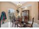 Dining room with wooden table, chairs, chandelier, and built-in cabinet featuring window with plantation shutters at 30723 Reed Rd, Dade City, FL 33523