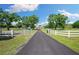 Long paved driveway leads to this house on acreage with white fencing at 30723 Reed Rd, Dade City, FL 33523