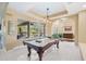 The game room features a pool table and large windows overlooking the outdoor space at 30723 Reed Rd, Dade City, FL 33523