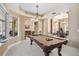 Game room features pool table and view into the dining area with bright, natural light at 30723 Reed Rd, Dade City, FL 33523
