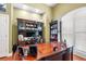 Well-lit home office with a large wooden desk, built-in shelving, and shuttered windows at 30723 Reed Rd, Dade City, FL 33523