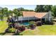 Backyard oasis featuring a screened-in pool area surrounded by beautiful landscaping and mature trees at 30723 Reed Rd, Dade City, FL 33523