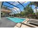 Serene screened-in pool with inviting lounge chairs and a lush, private backyard setting at 30723 Reed Rd, Dade City, FL 33523