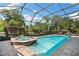 Sparkling pool and spa area enclosed with a screened lanai, surrounded by lush landscaping at 30723 Reed Rd, Dade City, FL 33523