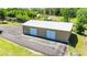 Large workshop with multiple garage doors and a paved driveway, surrounded by mature trees at 30723 Reed Rd, Dade City, FL 33523