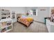 Bright bedroom featuring a colorful bedspread, white shelving, and natural light from the window at 3096 Great Banyan Way, Wesley Chapel, FL 33543