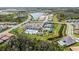 Aerial view of the community pool, clubhouse, tennis courts, and playground in a landscaped setting at 3096 Great Banyan Way, Wesley Chapel, FL 33543