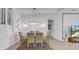 Dining room features a glass table with seating for six, stylish light fixture, and decorative wall art at 3096 Great Banyan Way, Wesley Chapel, FL 33543