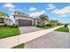 Charming home featuring stone accents, well-maintained landscaping, and a brick-paved driveway at 3096 Great Banyan Way, Wesley Chapel, FL 33543