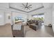 Spacious living room with decorative wall, ceiling fan, and sliding glass doors leading to the lanai at 3096 Great Banyan Way, Wesley Chapel, FL 33543
